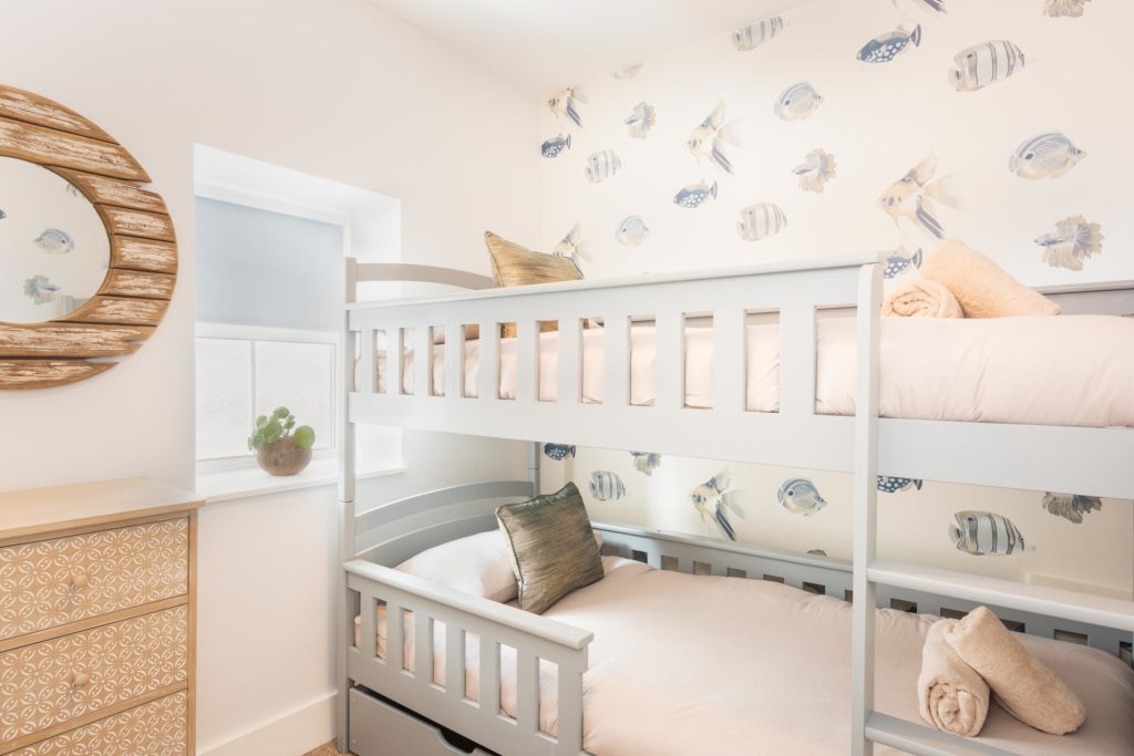 bunk beds of holiday cottage in Lyme Regis with fish theme wallpaper by Jurassic Properties