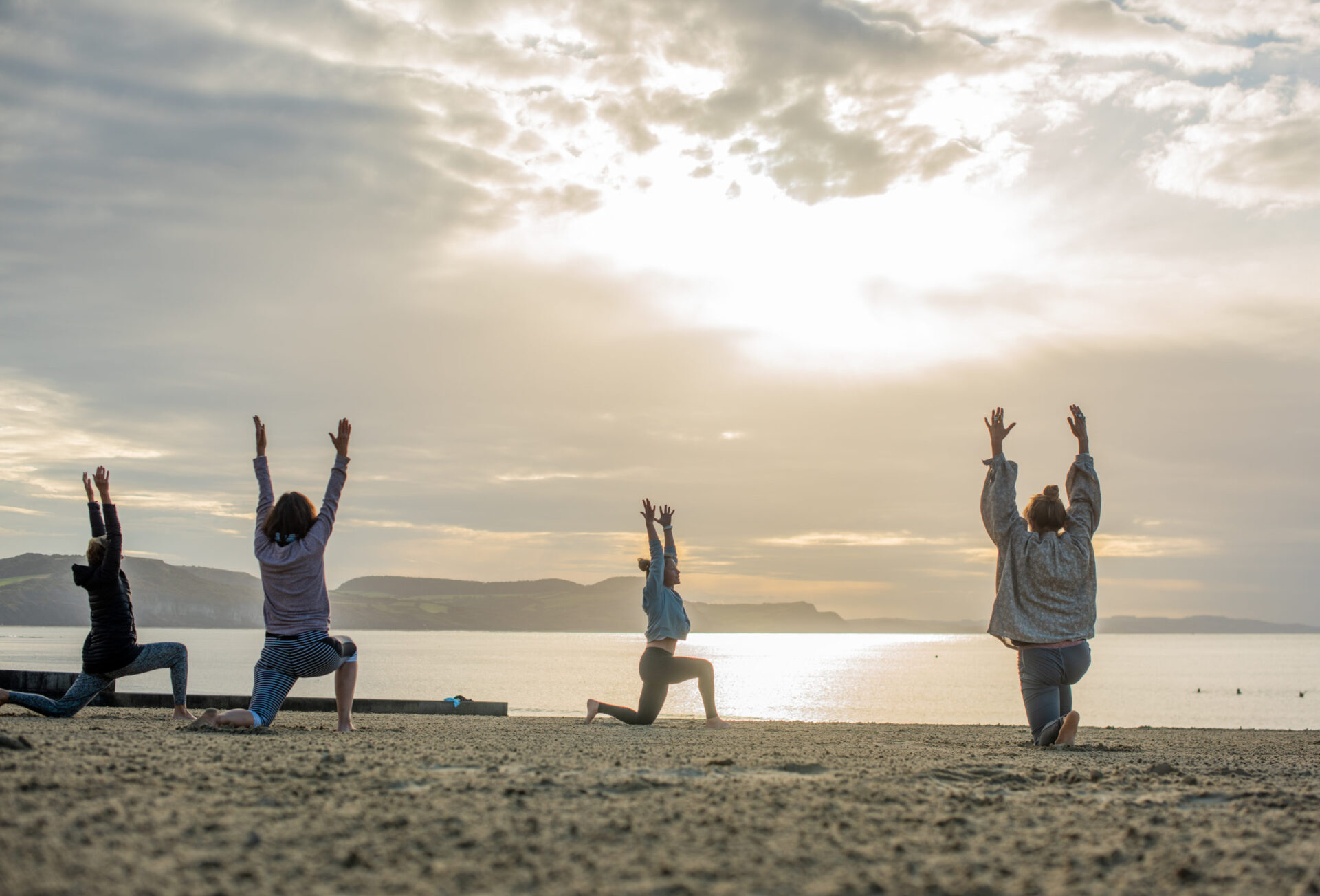 Lyme Regis group yoga class with morning sunrise