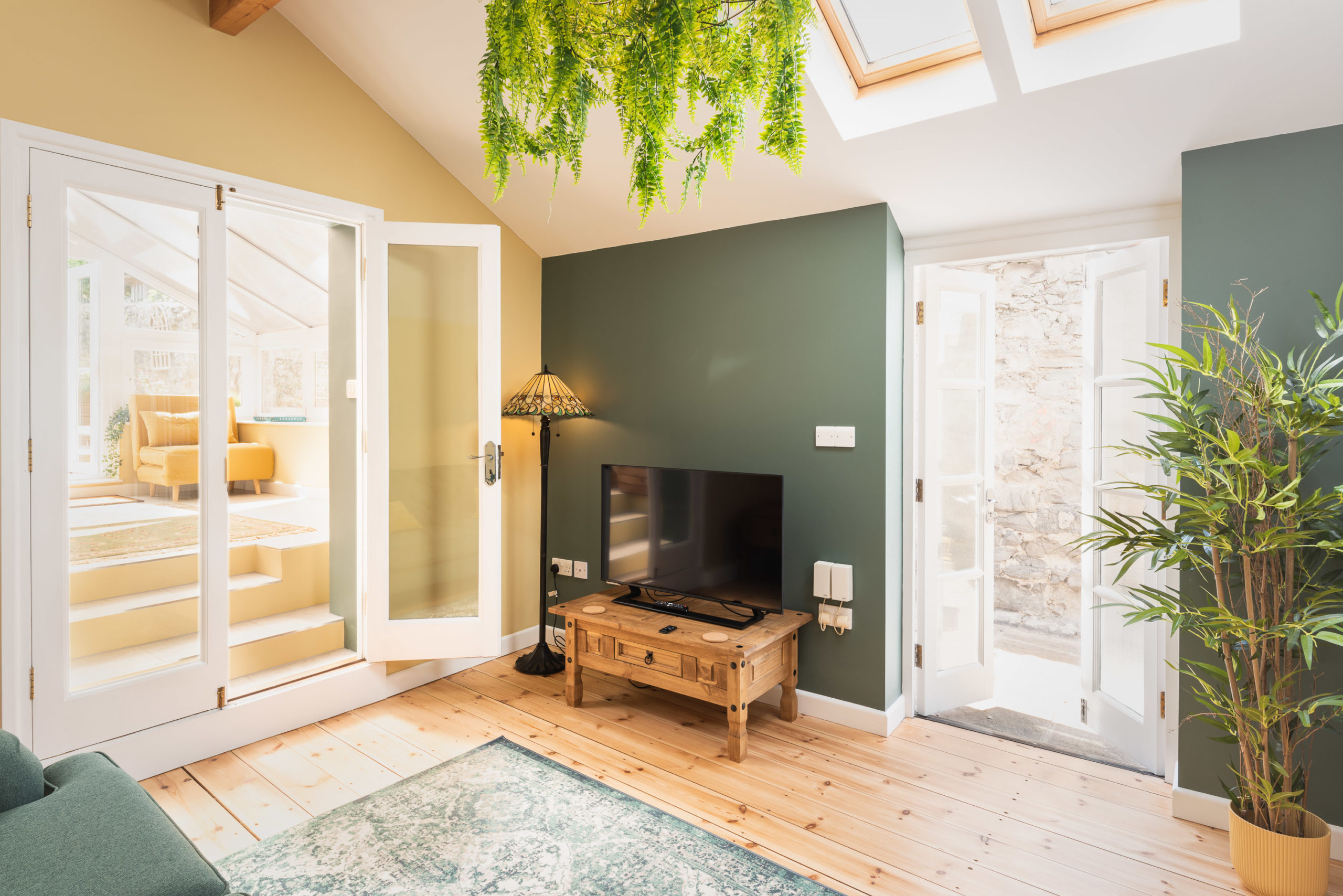 lyme regis holiday cottage living area with smart tv and bold green decor